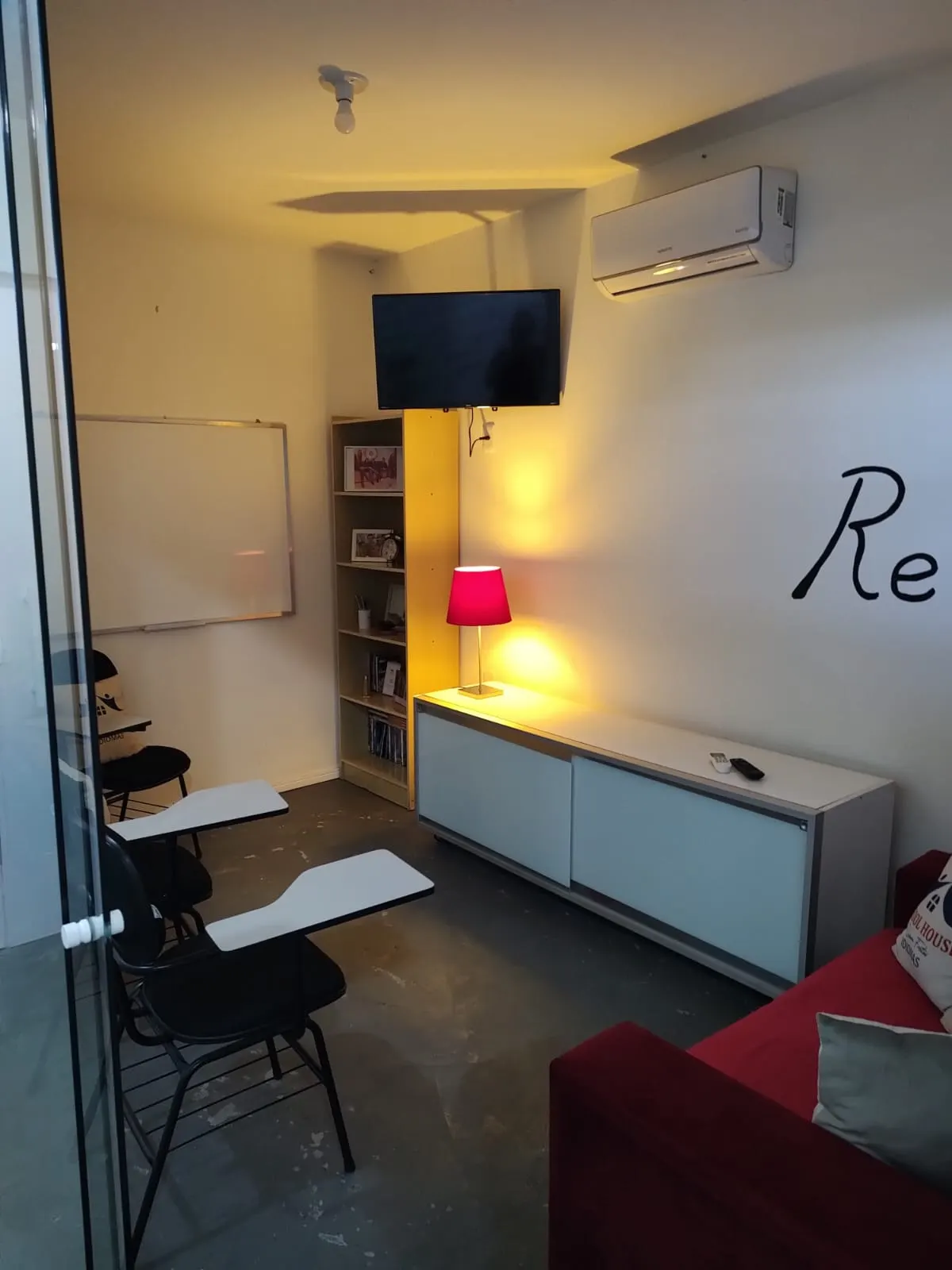 Espaço de descanso da School House, com sofá e tapete