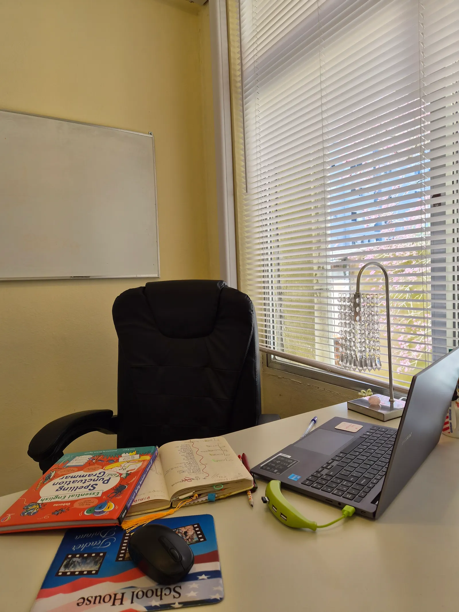Sala individual da School House em Guaíba, com mesa, notebook e livros de inglês